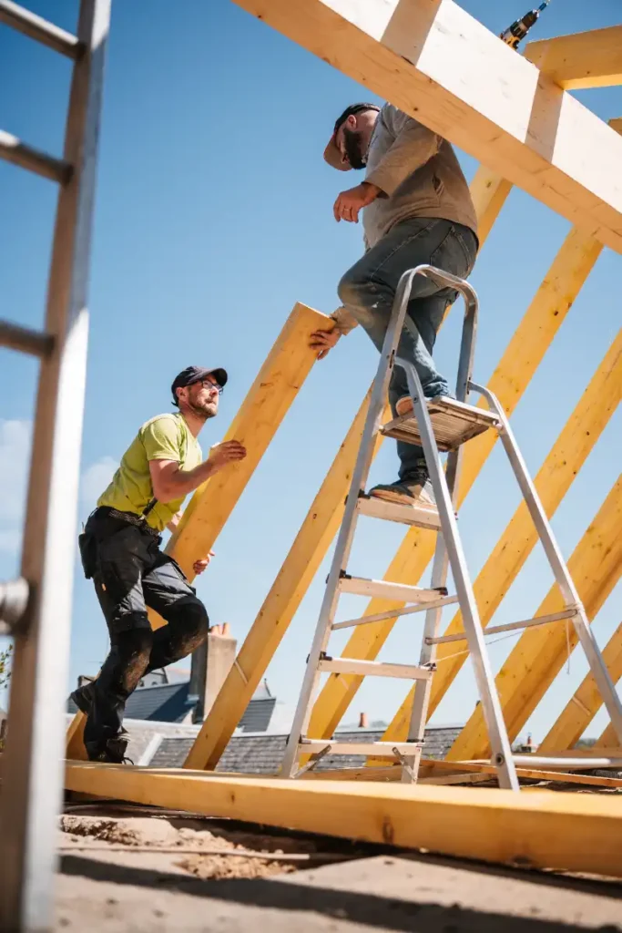 2 ouvriers en train de procéder à une rénovation de toiture